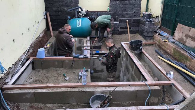 Handwerker arbeiten am Pool im Garten eines Kunden