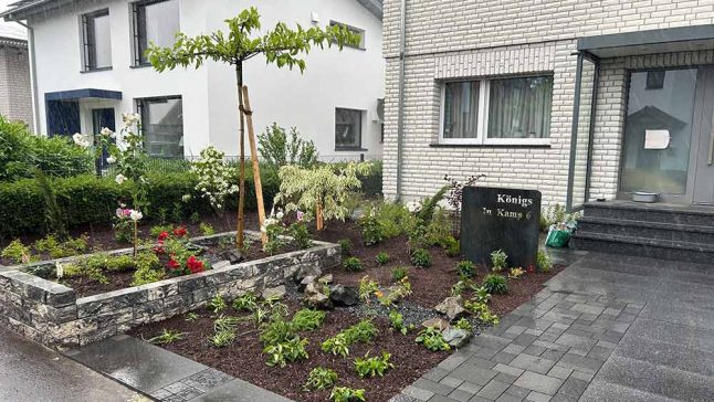 Neu gestalteter Vorgarten mit Natursteinbeet und Bepflanzung